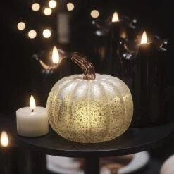Citrouille Lumineuse En Verre à La Patine Blanche 25 Citrouille Lumineuse En Verre à La Patine Blanche -Boutique De Noël citrouille lumineuse en verre a la patine blanche sur une table basse